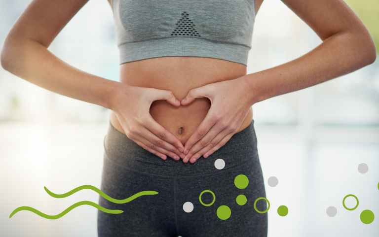 Una foto de una mujer formando un corazón con su manos en su barriga.